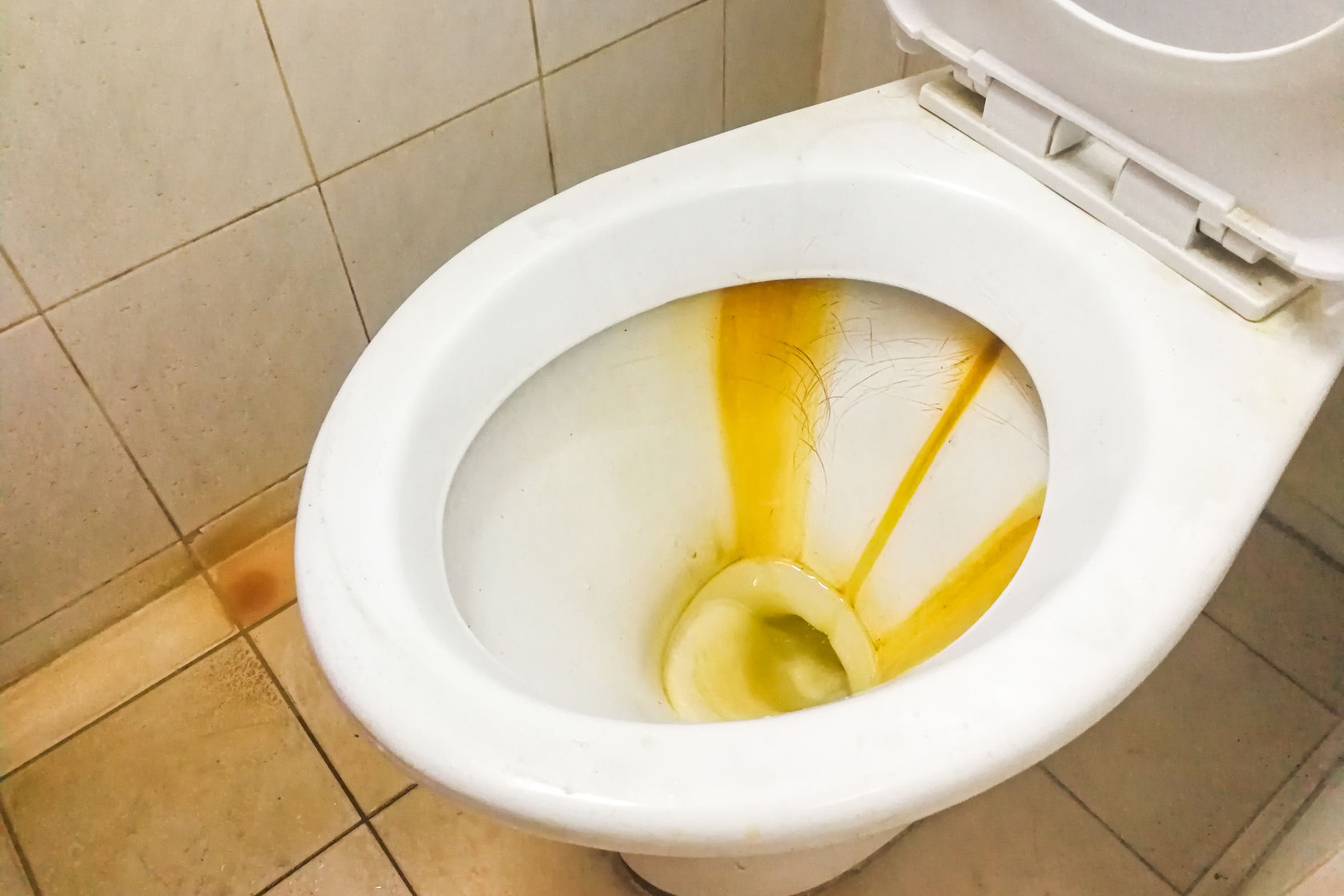 A dirty toilet bowl with rust stains